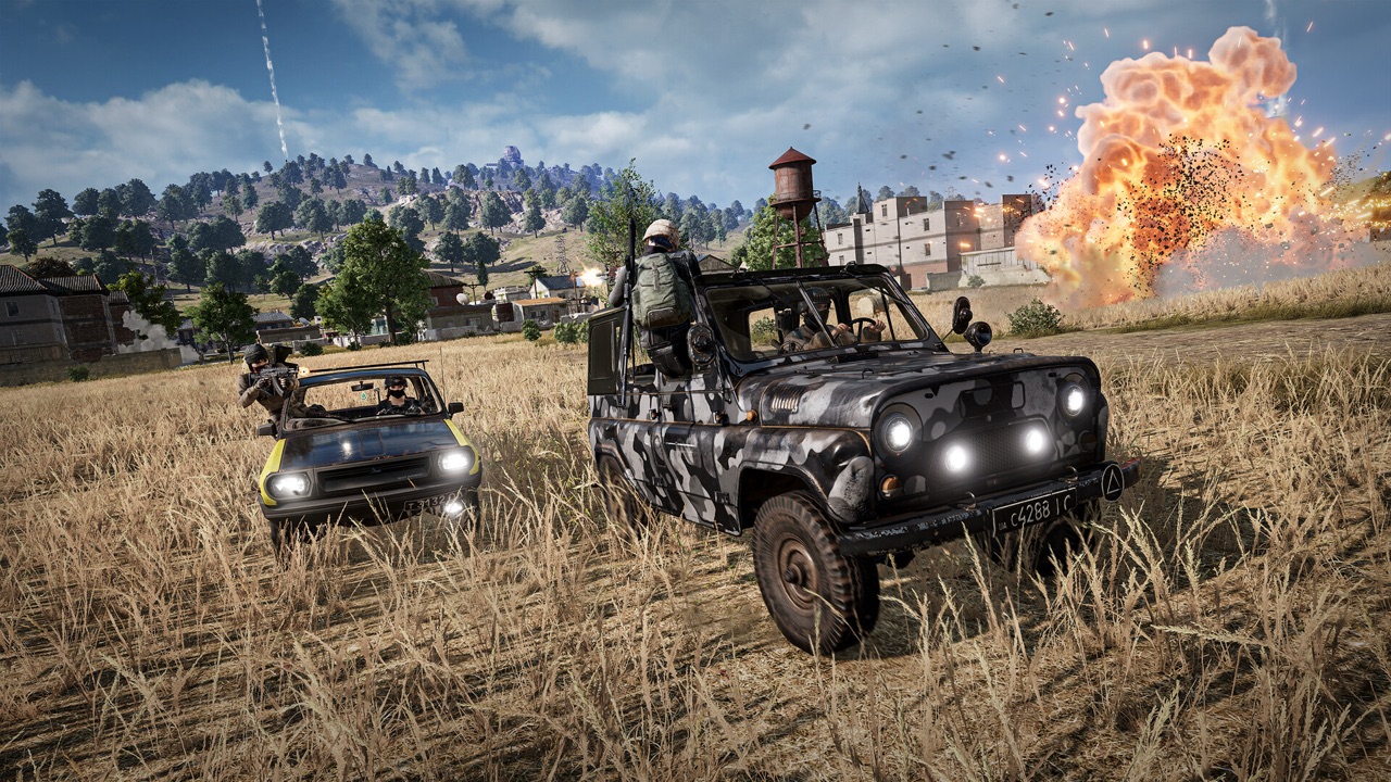 Two PUBG players in armed vehicles speeding across an open field as a building explodes in the distance — the kind of chaotic battle royale moment designed for squads, not solo queues