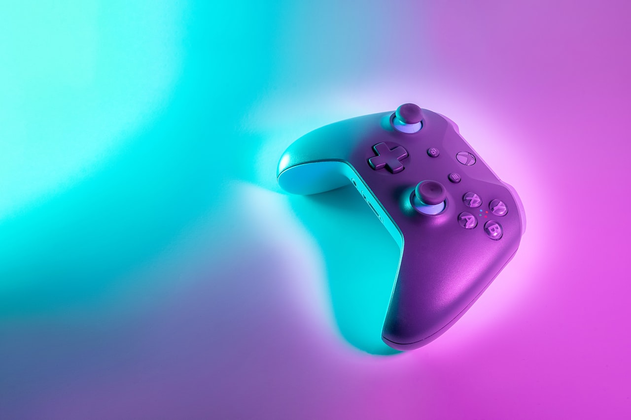 Gaming controller under vibrant neon teal and pink gradient lighting