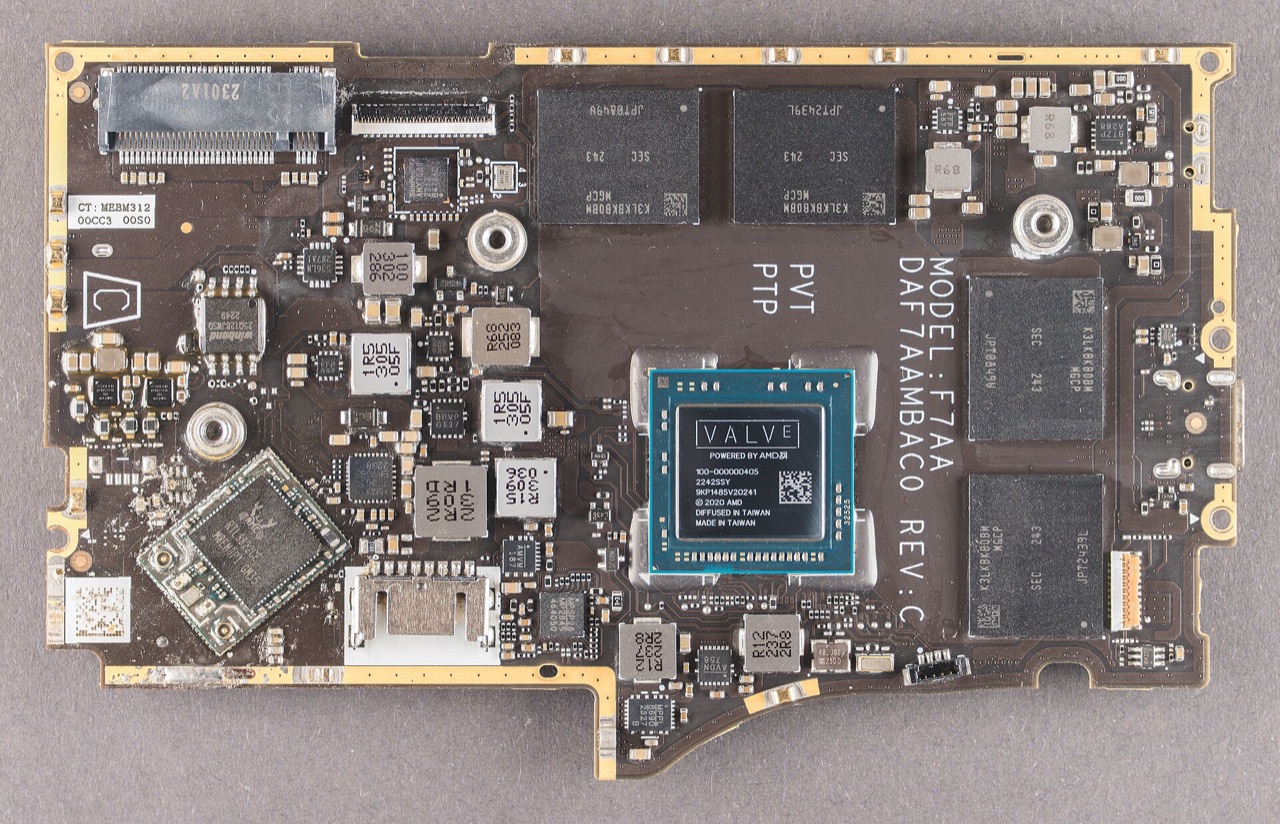 Extreme macro photograph of the Steam Deck's AMD Van Gogh APU die sitting on its green package substrate, gold traces visible around the silicon